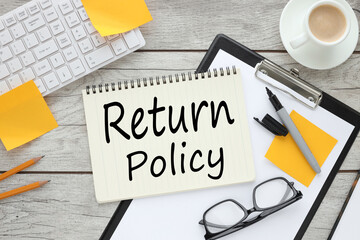 Return Policy wooden background open notepad on folder with clip.