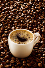 xícara de café expresso cremoso sobre fundo de grãos de café torrado em fundo branco 