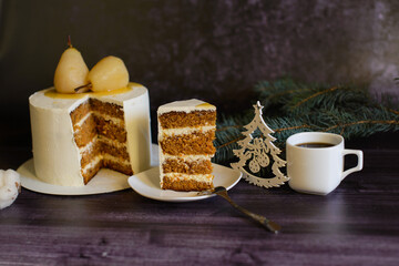 carrot cake, decorated with pears, with a piece cut off next to it, on a saucer