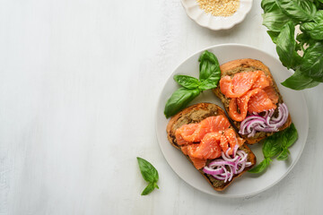 Sandwiches with salted salmon, avocado guacamole, red onions and basil. Smorrebrod. Set of danish open sandwiches. Healthy food, breakfast. Clean eating, dieting, vegan food concept. Top view.