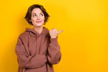 Photo of nice seller girl direct finger empty space novelty poster billboard wear brown hood shirt...