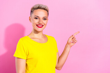 Photo of positive gorgeous lady beaming smile direct finger empty space isolated on pink color background