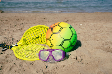 Fototapeta na wymiar Beach tennis racket and ball, swimming mask ,and beach volleyball ball on tne beach