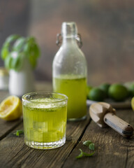 lemonade with lime and basil on a wooden table
