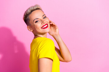 Profile portrait of stunning cheerful girl hand touch cheek face beaming smile empty space isolated on pink color background
