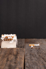 Smoking cessation concept.  Open pack of cigarettes on a wooden table with one cigarette broken in half.