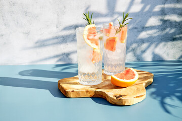 Chilled drink with fresh citrus fruits and rosemary. Summer cocktails with grapefruit or red orange.