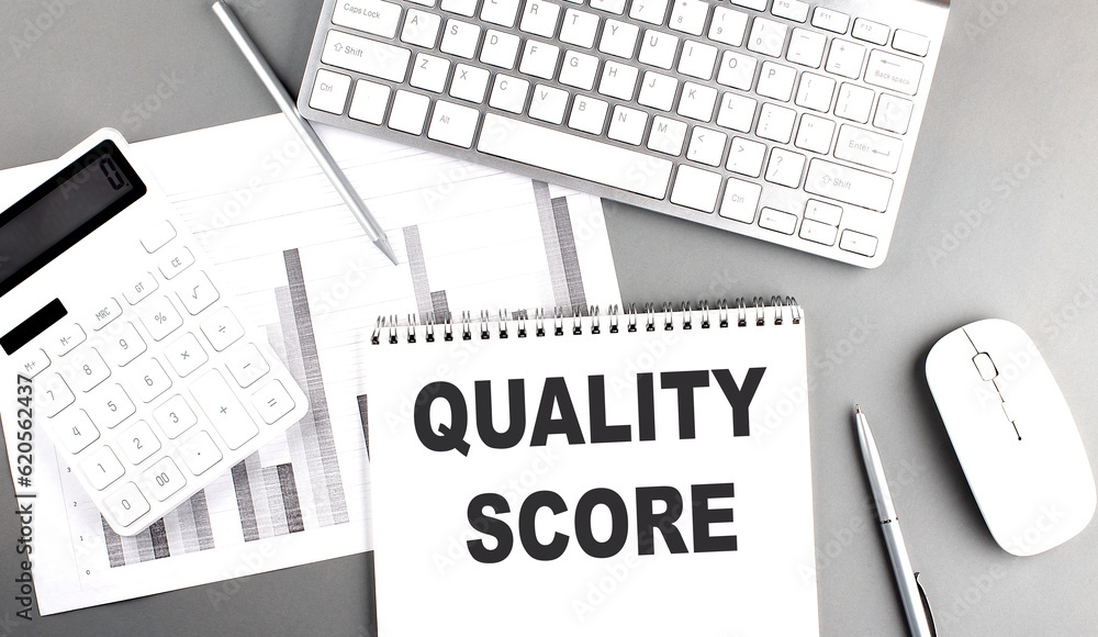 Poster quality score text written on notebook on grey background with chart and keyboard , business concept