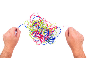Closeup hands try to solve the confused ropes on white background, psychotherapy, mental complex