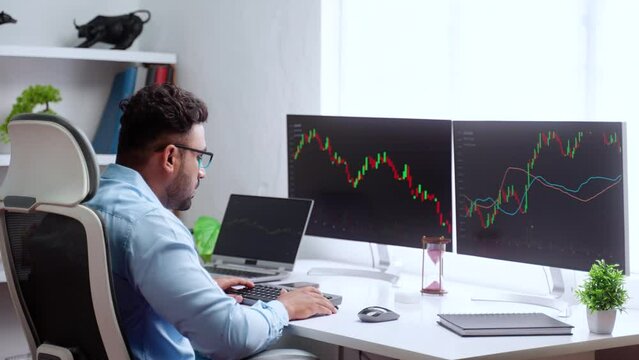 Shoulder shot of professional trader analyzing charts on monitor at office - concept of Technical Analysis, Professional investor and Risk Management