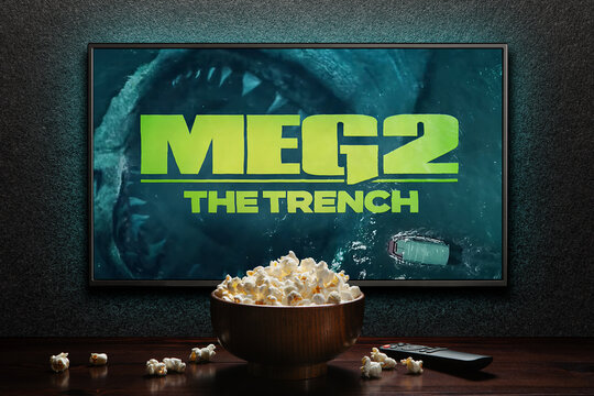 Meg 2 The Trench trailer or movie. TV with remote control and popcorn bowl. Astana, Kazakhstan - July 2, 2023.