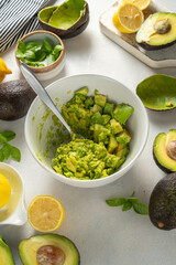 Guacamole in a bowl, cooking homemade avocado mash dip. 