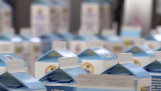 A line of dairy products. Packages of dairy products are moved along a conveyor line at the factory. Production conveyor belt at the dairy plant.