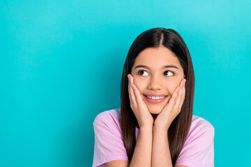 Fototapeta premium Photo of adorable dreamy little child dressed pink t-shirt arms cheeks looking empty space isolated teal color background