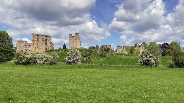 View of the medieval ruins of Helmsley Castle in the stunning North York Moors. The castle sits above a vibrant grass area. Taken on a sunny spring day - North Yorkshire, UK