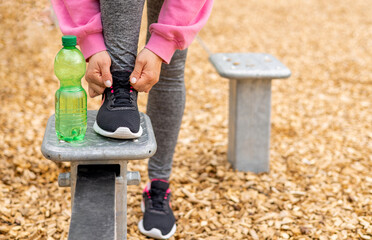 young woman in outside outdoor gym using cable chest for workout or parallel bars.girl female is...