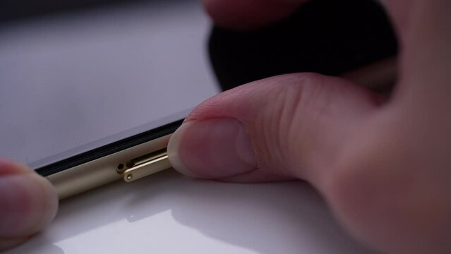 Person extract a sim card from a mobile phone, Sim card in tray being inserted into phone