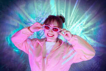 Cool teenager. Fashionable girl in pink sport trendy jacket and vintage retro sunglasses enjoys...