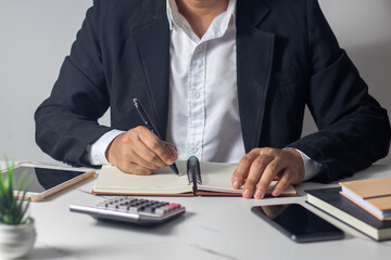 Male hand writing a note in a notebook concept of business people working