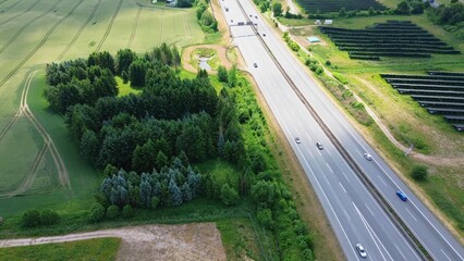Aerial view of the A7 motorway in northern Germany with big solar panel areas close to the highway. - obrazy, fototapety, plakaty