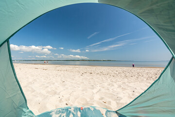 View from inside a tent onto beautiful white sand beach at the Baltic Sea at the Flensburger Förde in North Germany