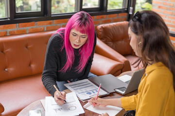 LGBTQ+ transgender man Beautiful Authentic Specialist with Pink Hair and Non-binary trans working together Working Design in creative workplace team work colleagues Gender equality