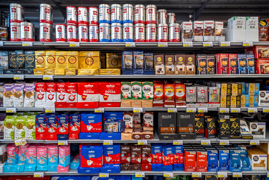 italy - july 06, 2023: packs of coffee of various types and brands on shelves for sale in italian supermarket