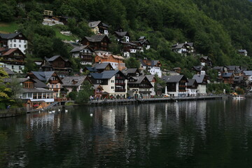Fototapeta na wymiar An Austrian Village Embraced by Towering Mountains and a Crystal-Clear Lake