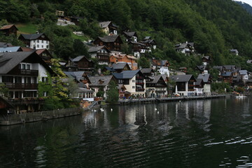 Fototapeta na wymiar An Austrian Village Embraced by Towering Mountains and a Crystal-Clear Lake