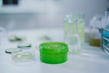 Cosmetic, skincare and treatment laboratory. Laboratory equipment and fresh cucumber slices in glassware, test tube or beaker. Concept of Serum, gel or cream essential experiment. Product advertise.