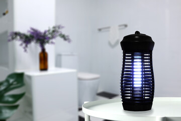 an insects mosquito electric blue light killer lamp is put on the white steel table in nice clean...