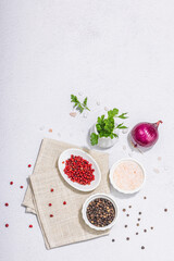 Fototapeta na wymiar Kitchen cooking background with assorted peppercorn, purple onion, fresh parsley and sea salt