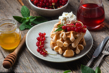 Belgian waffles with red currants in a bowl