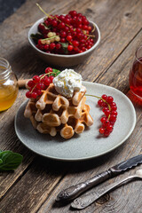 Belgian waffles with red currants in a bowl