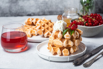 Belgian waffles with red currants in a bowl