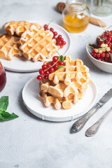 Belgian waffles with red currants in a bowl