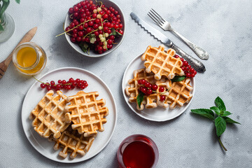 Belgian waffles with red currants in a bowl