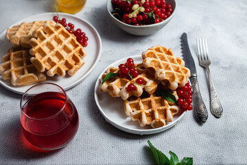 Belgian waffles with red currants in a bowl