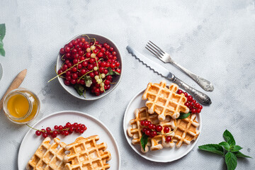 Belgian waffles with red currants in a bowl