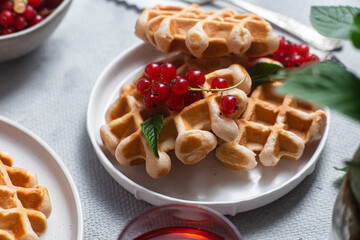 Belgian waffles with red currants in a bowl