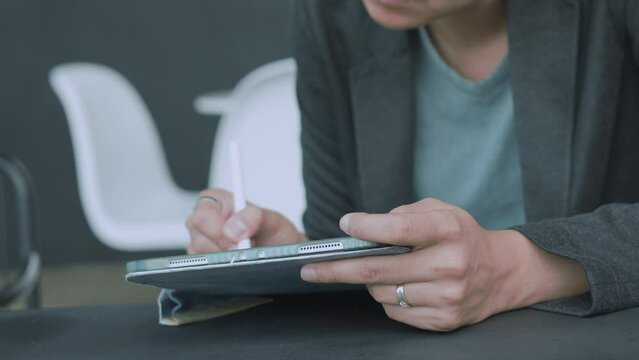 Hands with stylus tablet of Asian woman embraces the modern lifestyle. Witness the authentic connection she creates through the social network, leveraging wireless technology to excel as an executive.