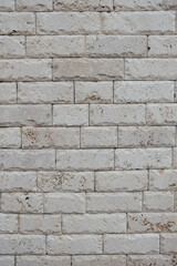 Texture of white marble-like tiles with jagged edges. Vertical image.