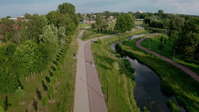 A cyclist riding along the Czarna Hańcza River in Suwałki. City of Suwalki in Poland. Cyclist. The Czarna Hańcza River.