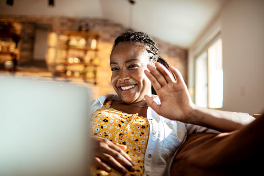 Young woman using a laptop while sitting on the couch in the living room