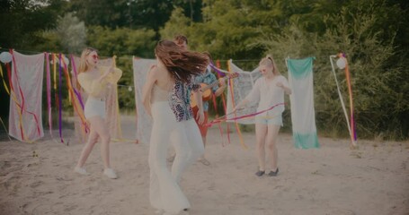 Woman and man dancing bachata by friends enjoying at beach