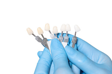 Doctor hands in medical sterile gloves hold shade guide bleach color, female veneer smile, dental...