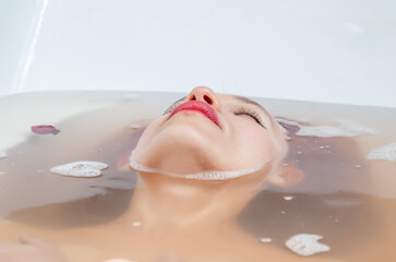 Face of beautiful woman immersed in water in the bath