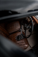 Oldtimer car dashboard. Retro car interior. Old steering wheel detail.