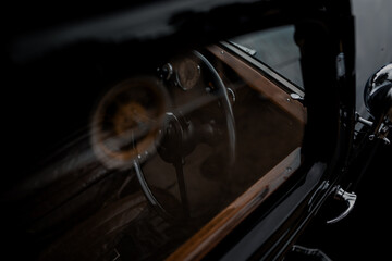 Oldtimer car dashboard. Retro car interior. Old steering wheel detail.