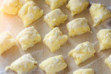 Sweet curd dessert. Sliced pieces of dough lie on the table in flour. View from above. Recipe for a delicious dessert at home.